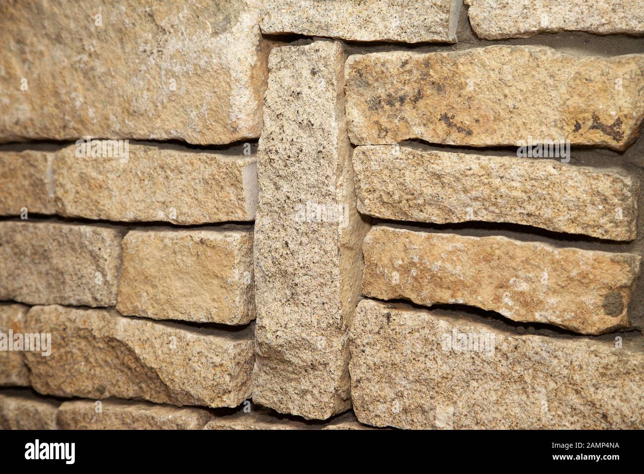 Close-up shot of a stone wall made of cut sandstone blocks. Stock Photo
