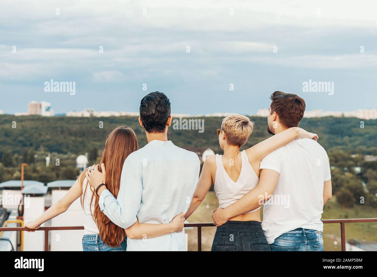 Group of friends enjoying outdoors at roof. Young friends at sunset on