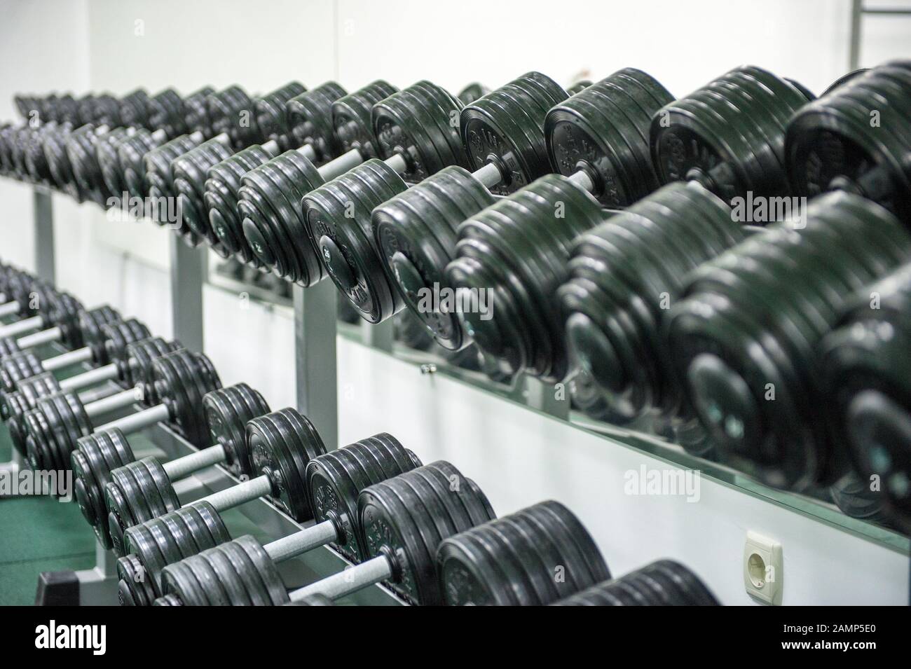 A row with dumbbells in the gym. Interior Stock Photo