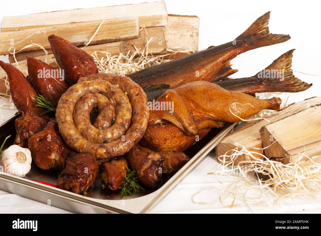 Smoked fish, poultry and sausages on a background with wood and sawdust Stock Photo