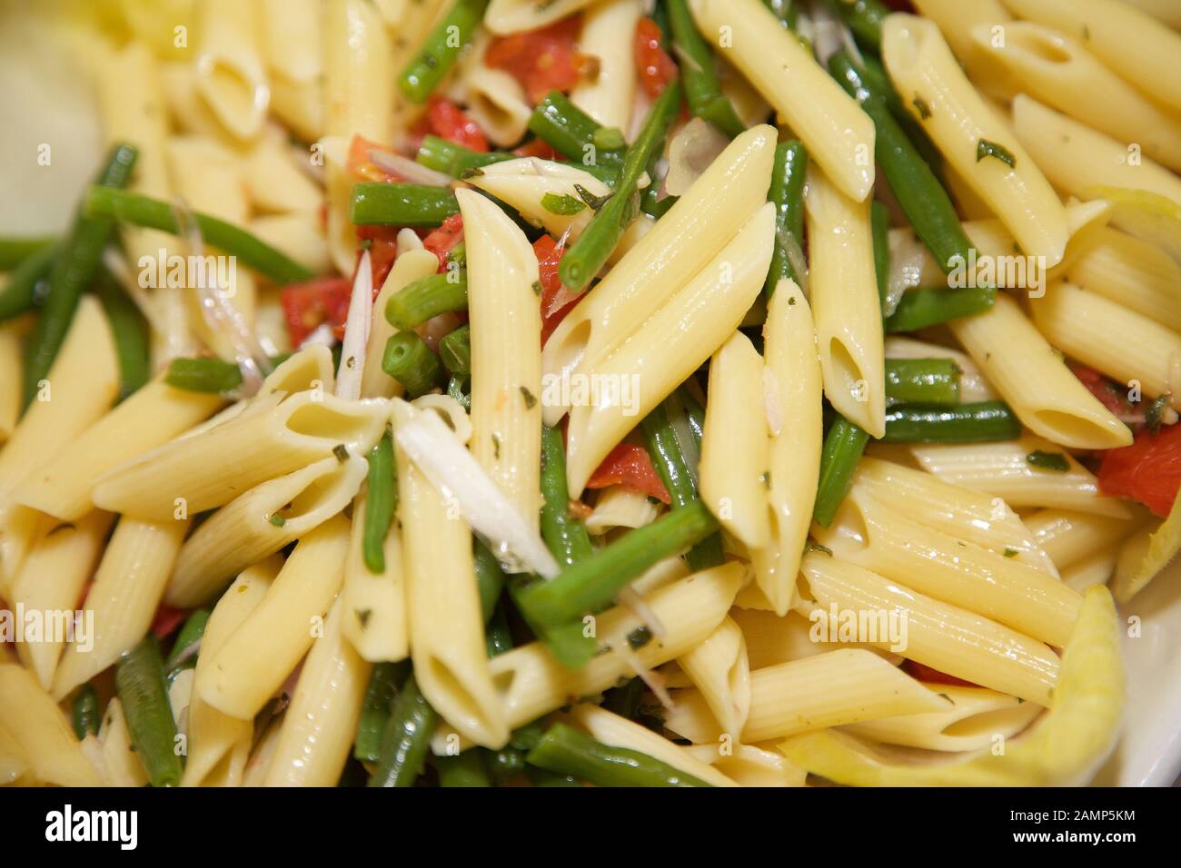 Freshly cooked penne pasta with green beans and tomatoes Stock Photo