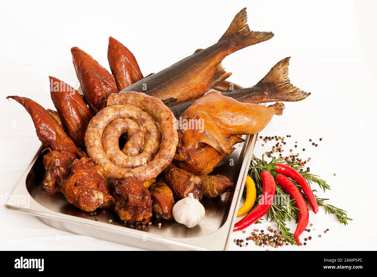 Smoked fish, poultry and sausages on a background with wood and sawdust Stock Photo