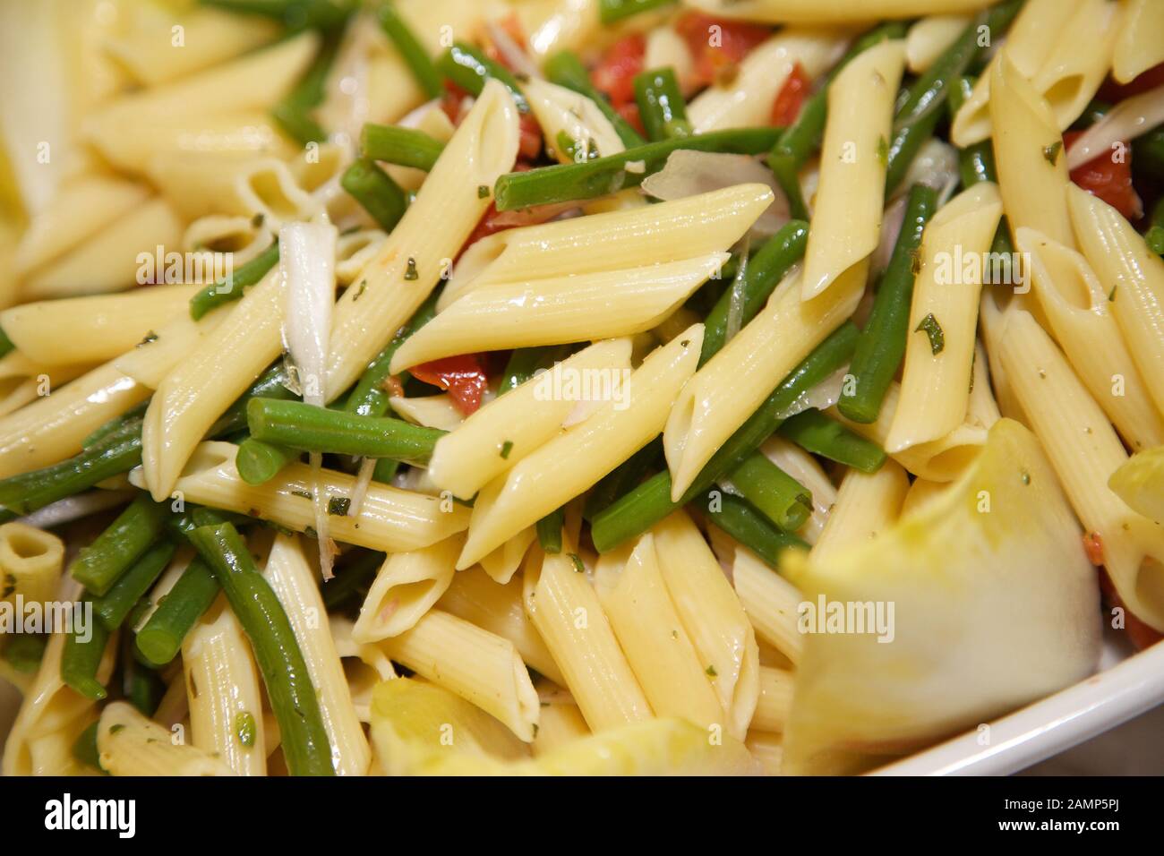 Freshly cooked penne pasta with green beans and tomatoes. Stock Photo