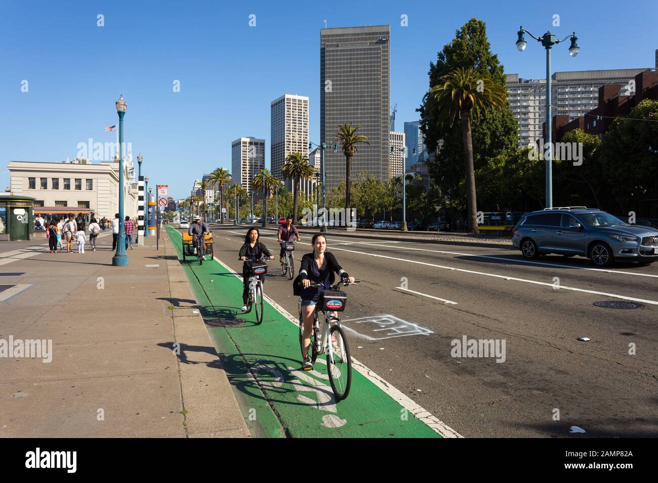 San Francisco - USA - July 5 2017: Young people ride bicyles front of the Embarcadero waterfront in San Francisco in California. Stock Photo