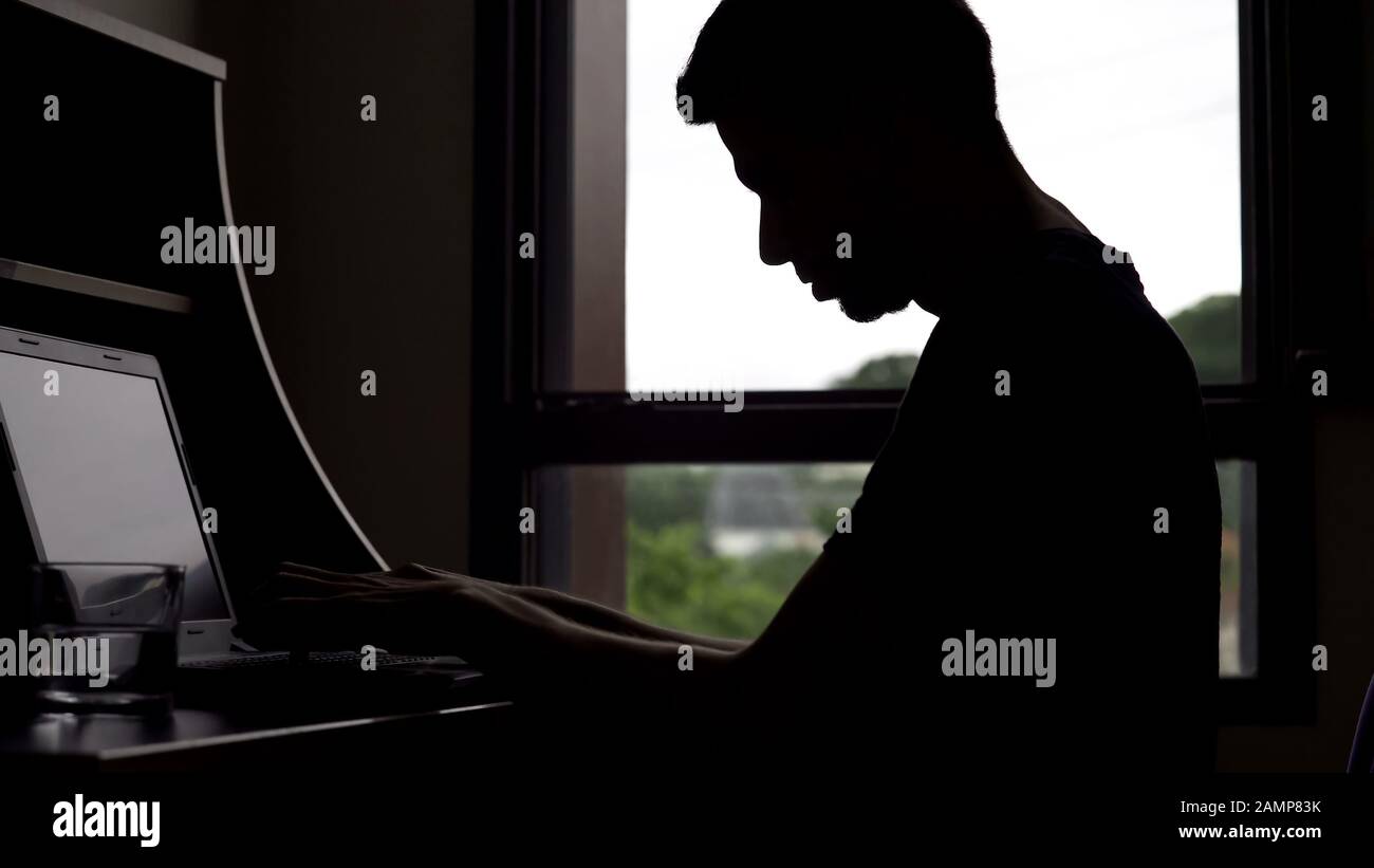 Man imagines playing piano, typing on computer keyboard, male writer silhouette Stock Photo