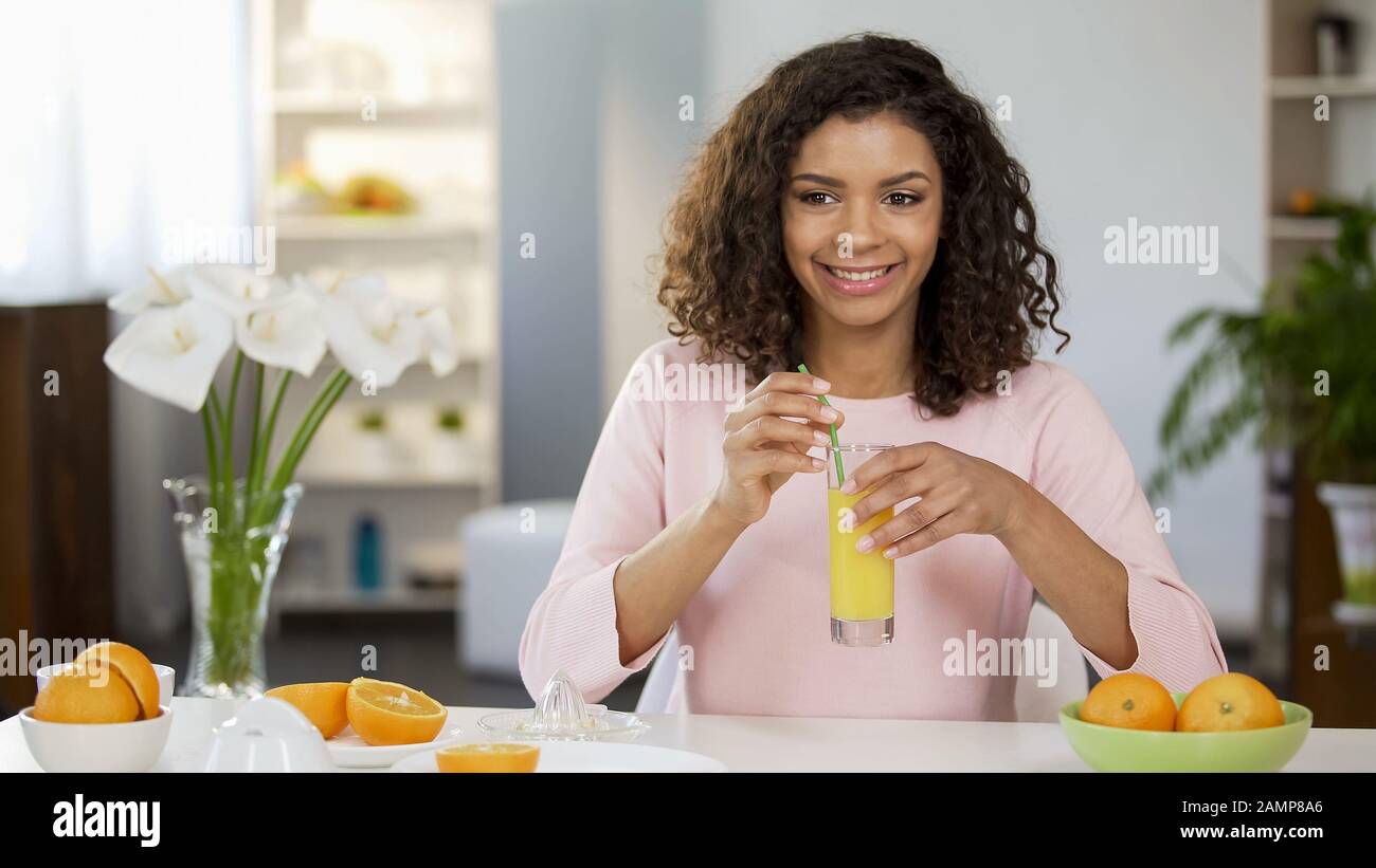 Smiling girl with fresh orange juice glass, organic nutrition