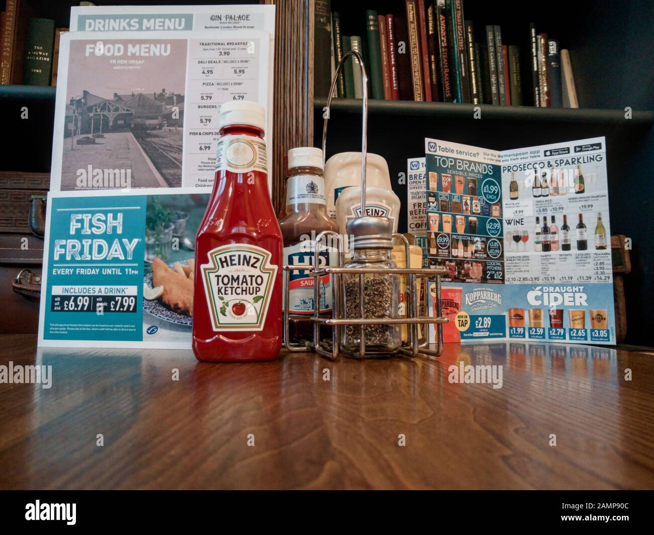 Table setup at JD Wetherspoons pub Yr Hen Orsaf (The Old Station) Aberystwyth, menu ketchup and other condiments Stock Photo