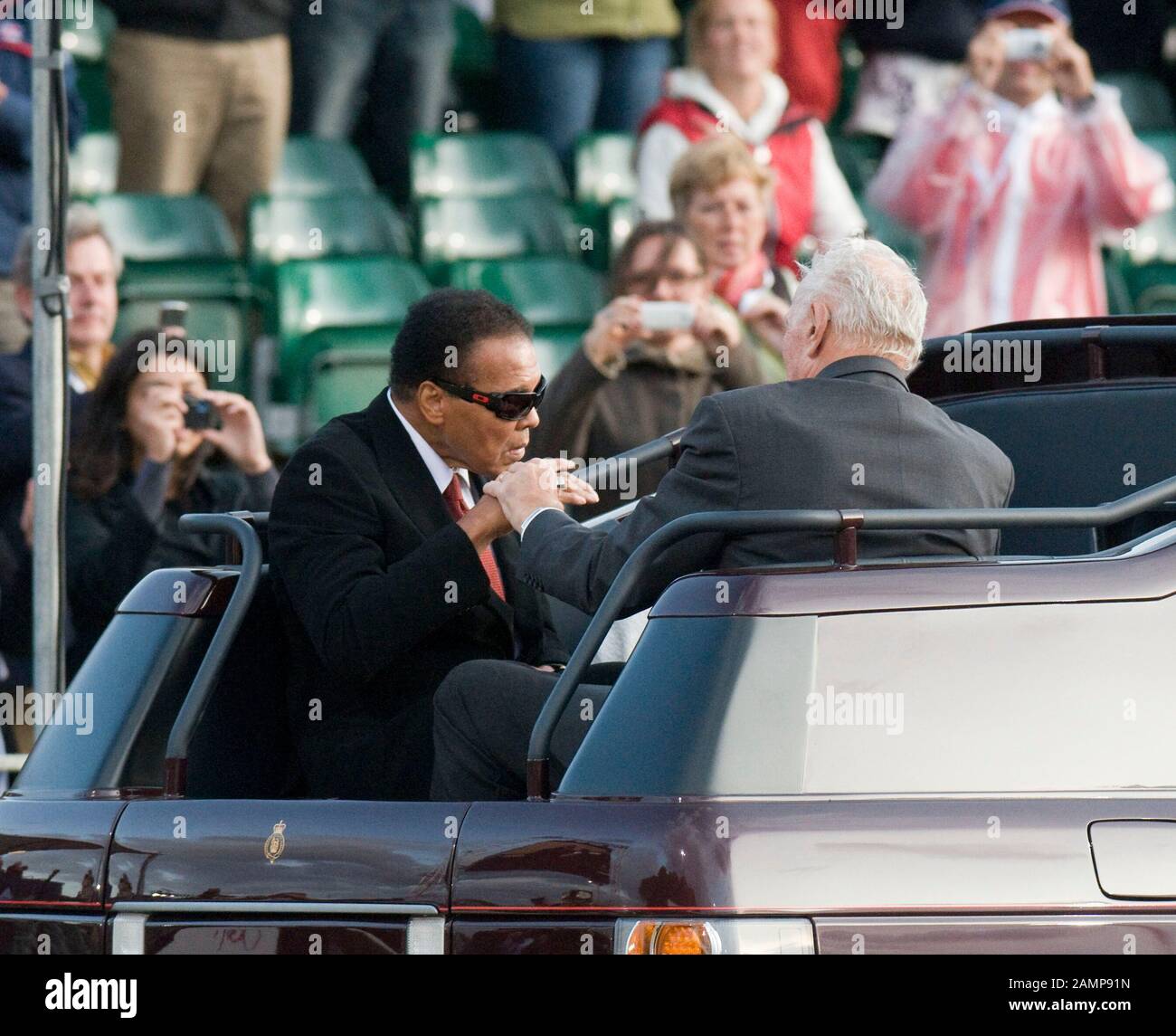 Muhammad Ali with wife Veronica and Sir Henry Cooper arrive in an Open top Range Rover belonging to the Royal Household  at the FEI Alltech Windsor European Jumping And Dressage Championships held at Windsor Castle. Stock Photo