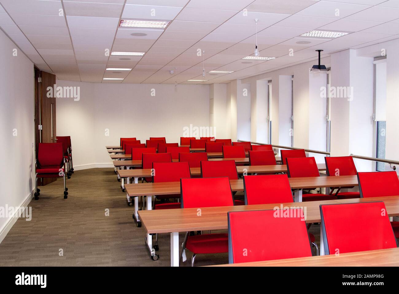 An empty lecture or seminar room with red chairs. Stock Photo