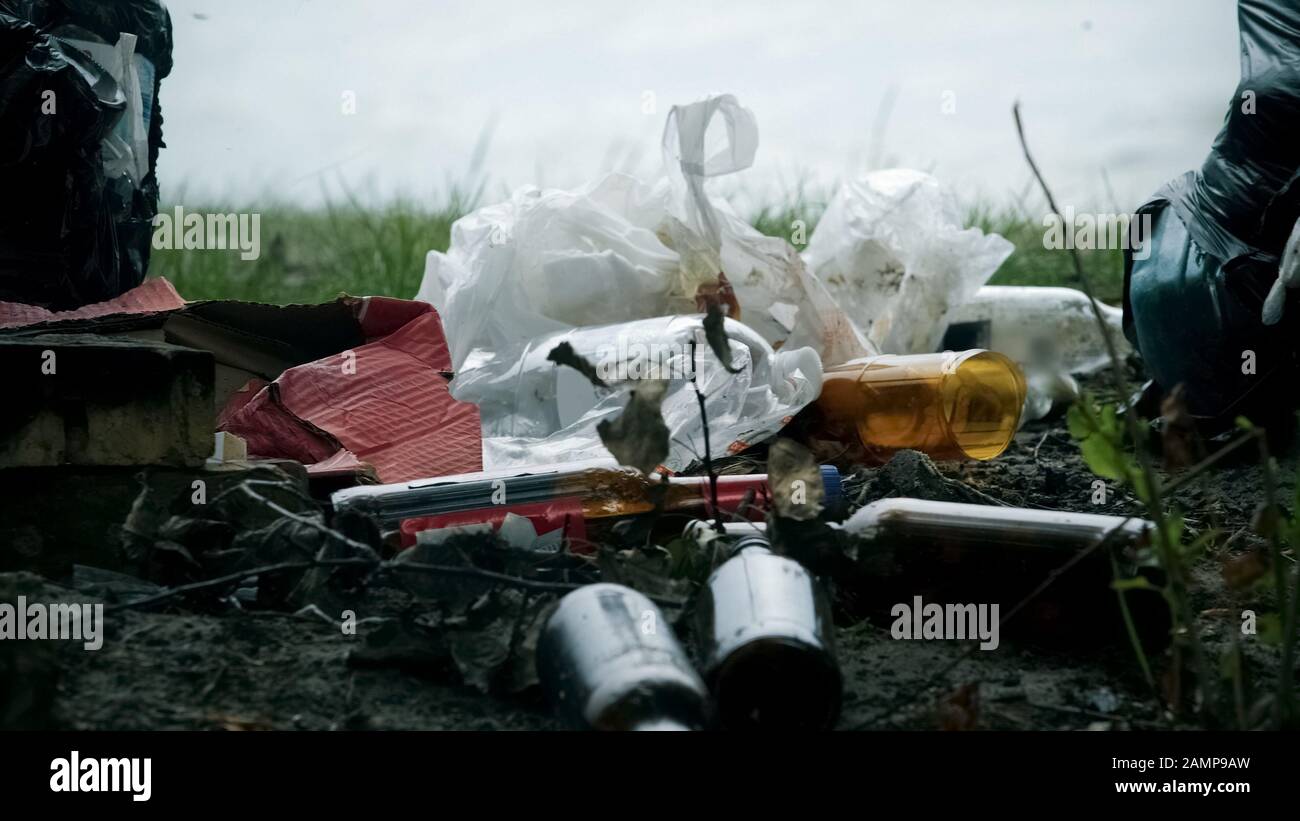 Pile of waste plastic and glass left after picnic, massive consumption problems Stock Photo