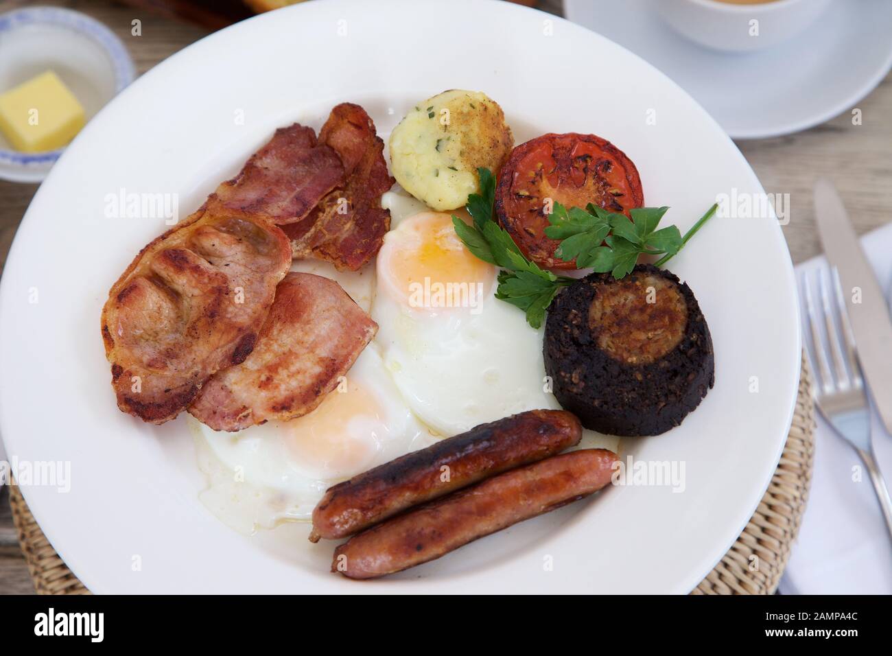 A full Irish breakfast consisting of bacon, egg, sausage, black pudding and grilled tomato. Stock Photo