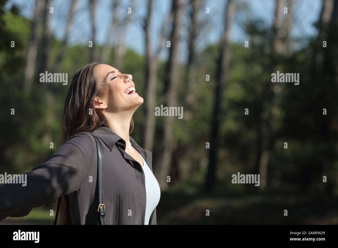 Side view portrait of a happy woman breathing fresh air in a park a ...