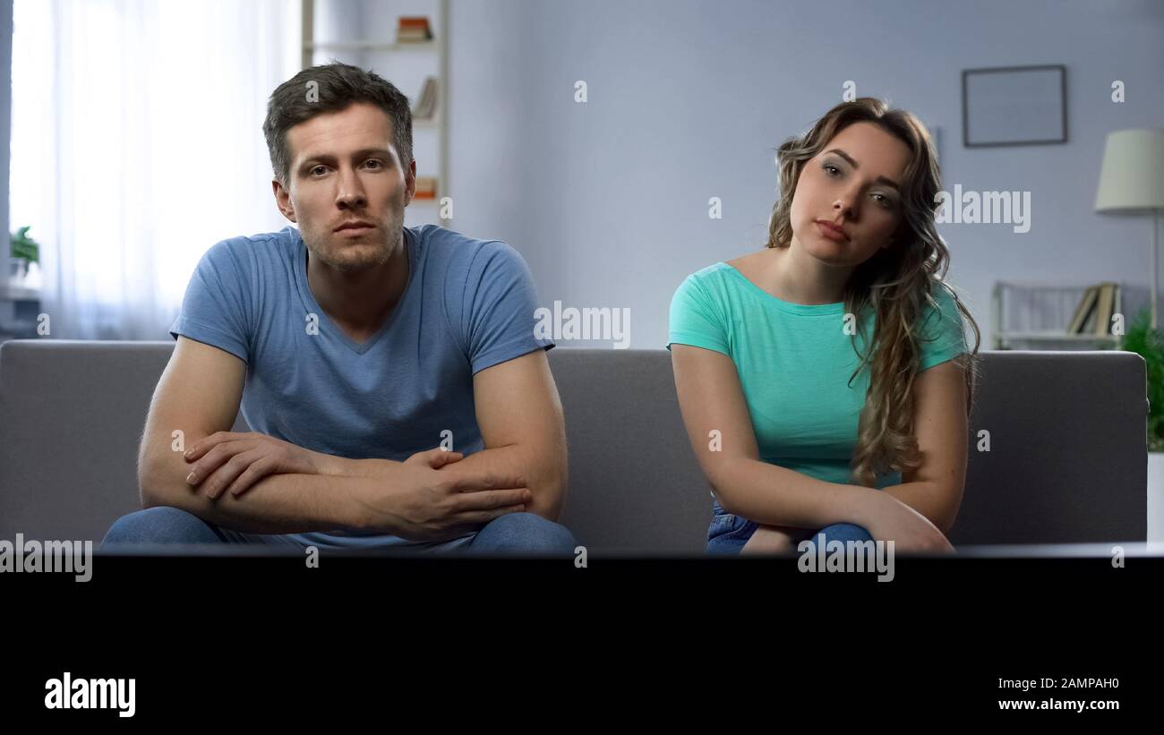 Couple in conflict watching tv silently ignoring each other, relationship crisis Stock Photo