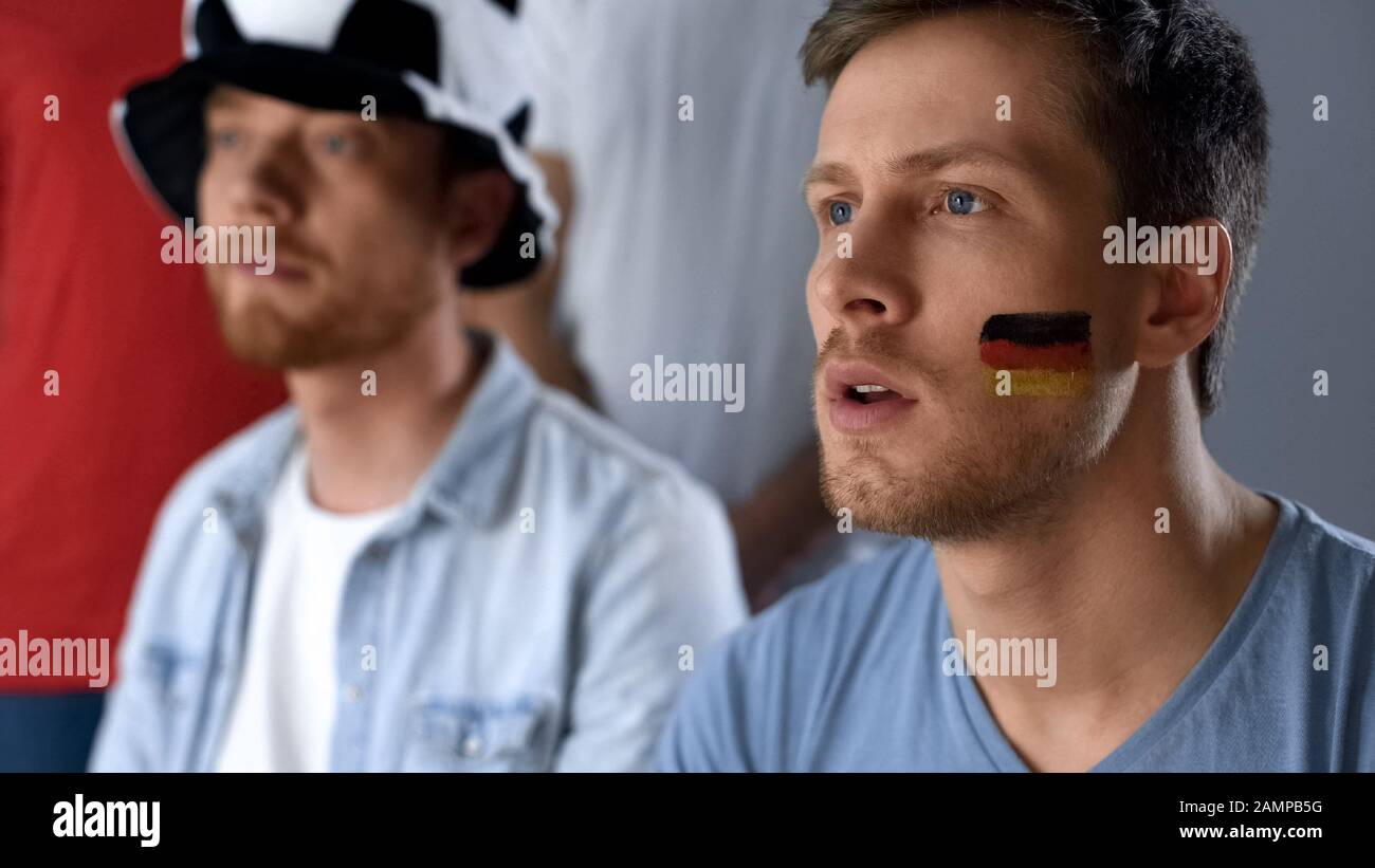 German football fans watching final game together in pub, hope of victory Stock Photo