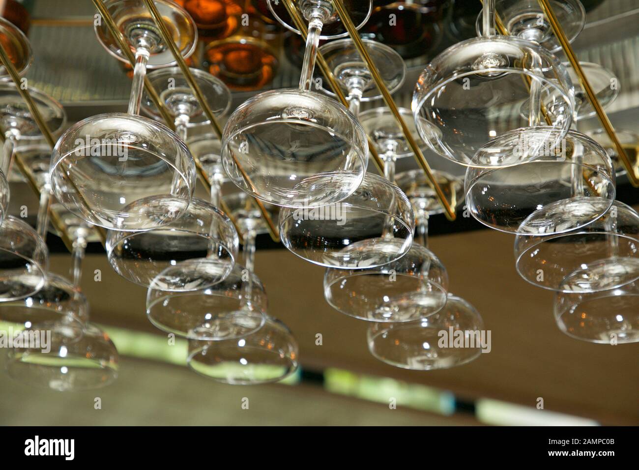 Drinking glasses hanging from a rack in a bar or restaurant. Stock Photo