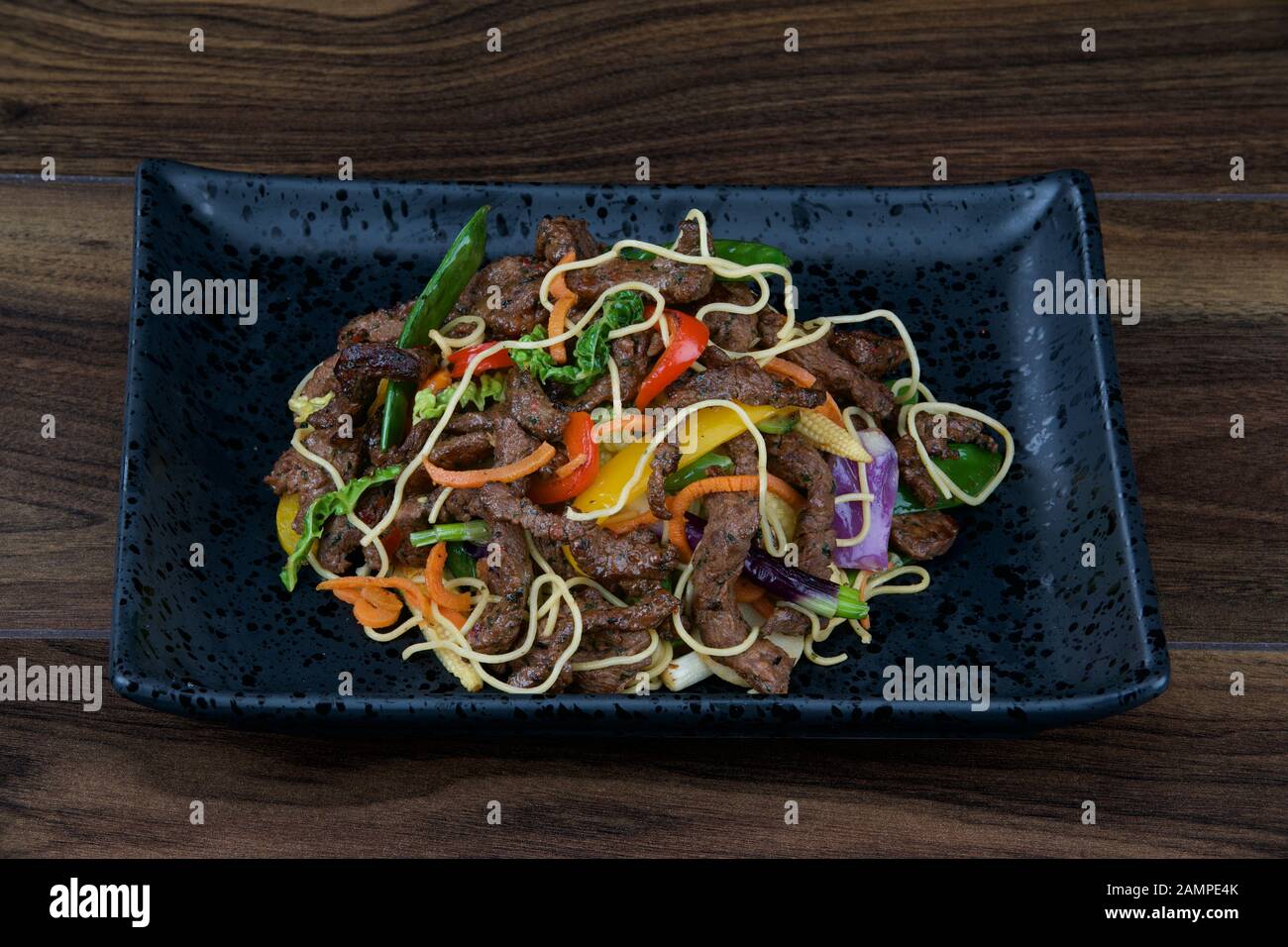 Asian stir fried beef served with noodles and vegetables. Stock Photo