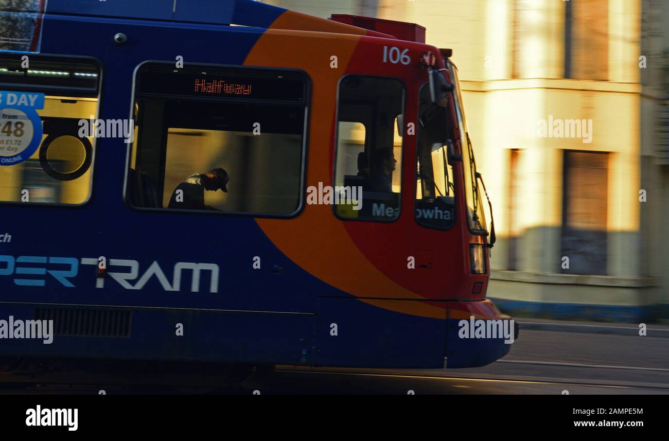 Sheffield Supertram with passenger passing a boarded up pub on an evening run Stock Photo
