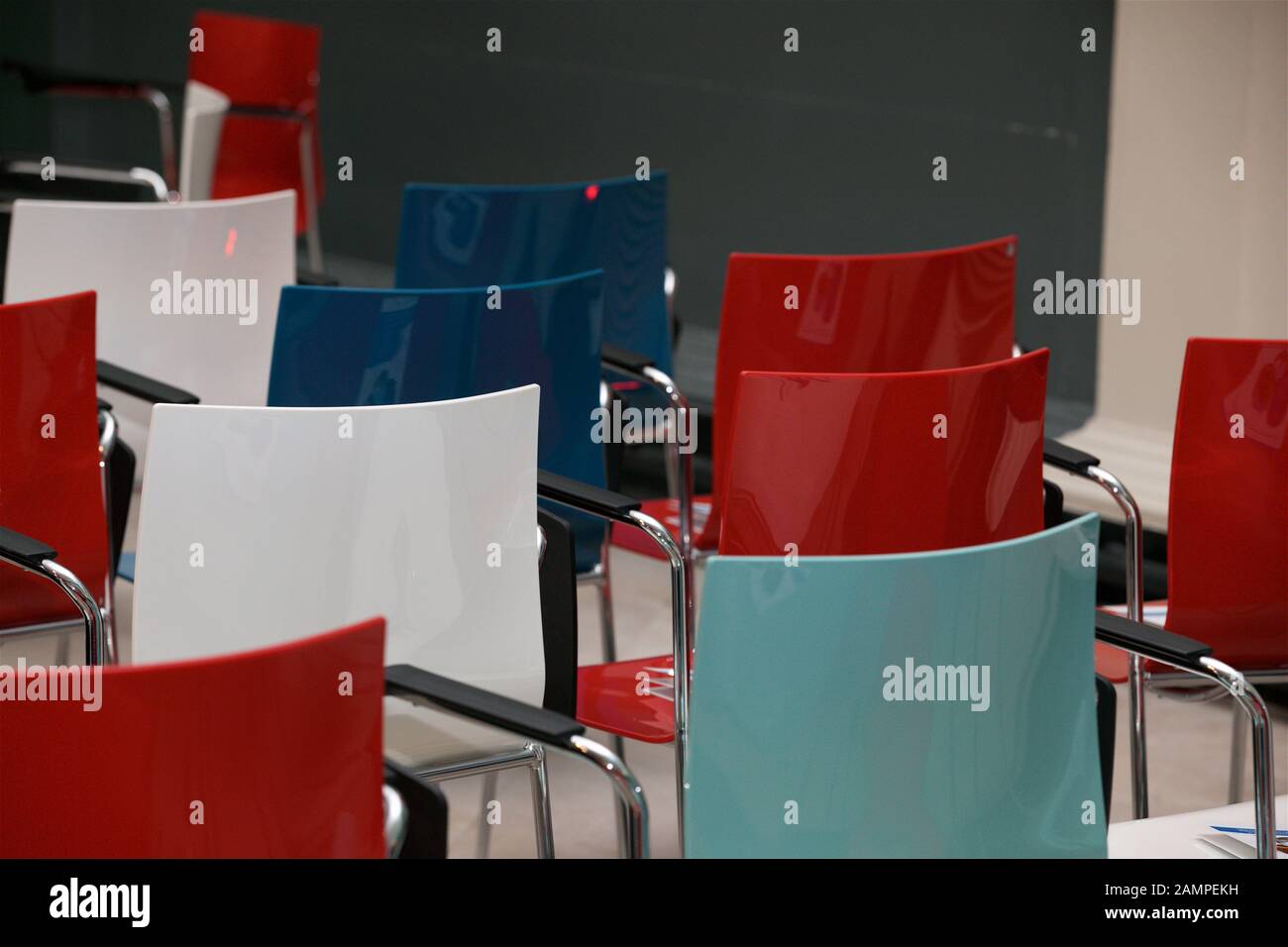 Rows of red, white and blue chairs in an empty seminar room Stock Photo