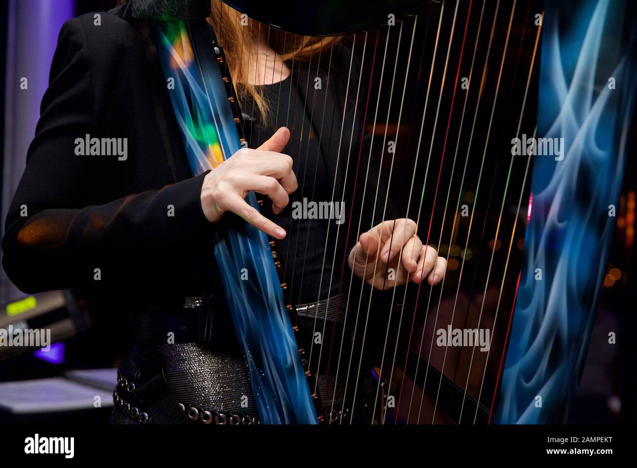 Close up shot of a woman playing a harp with multicoloured fibre optic lights embedded in the strings. Stock Photo