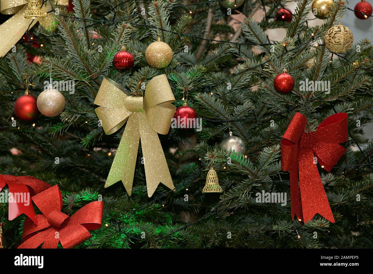 Christmas background: close up shot of a decorated Christmas tree with ribbons and baubles. Stock Photo