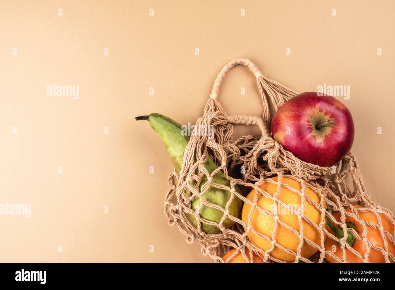 Fresh fruits and vegetables in a wicker ecofriendly bag on a beige background Stock Photo Alamy