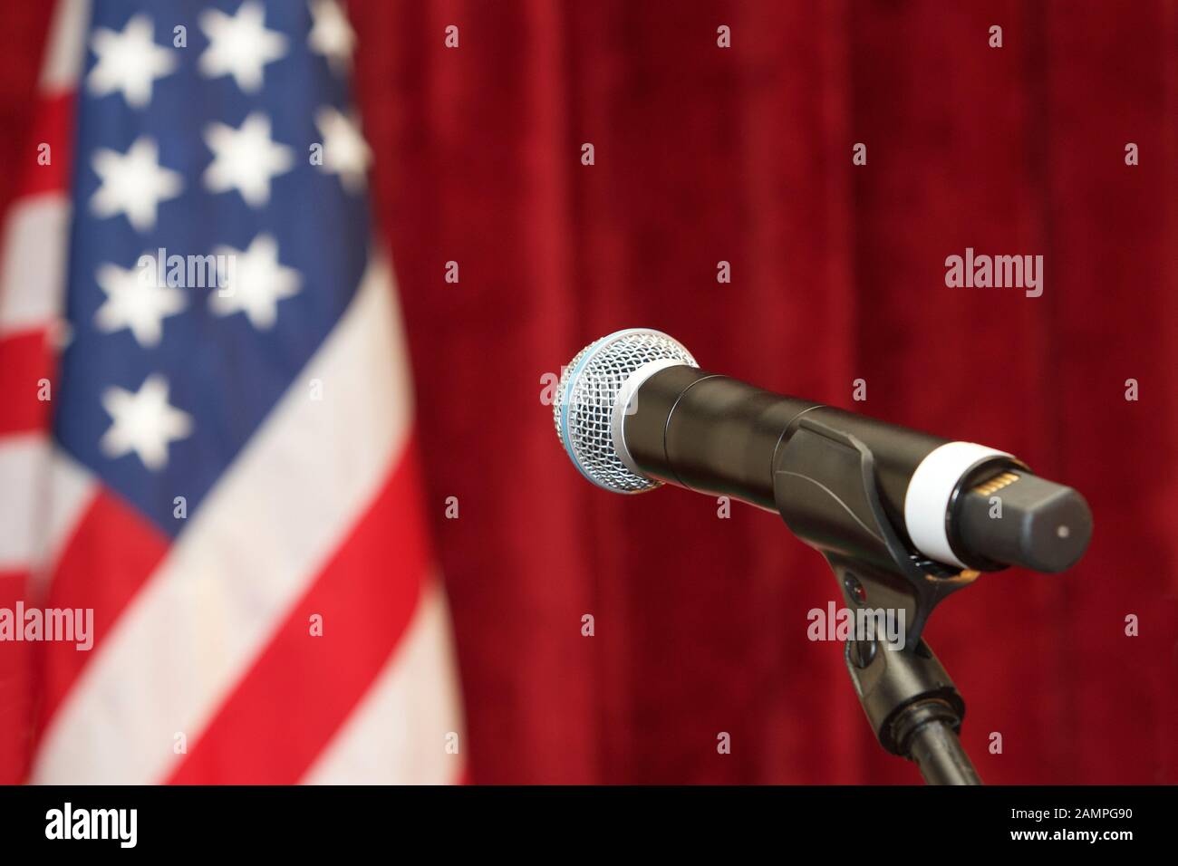 Wireless microphone on stand with American flag in the background. Stock Photo