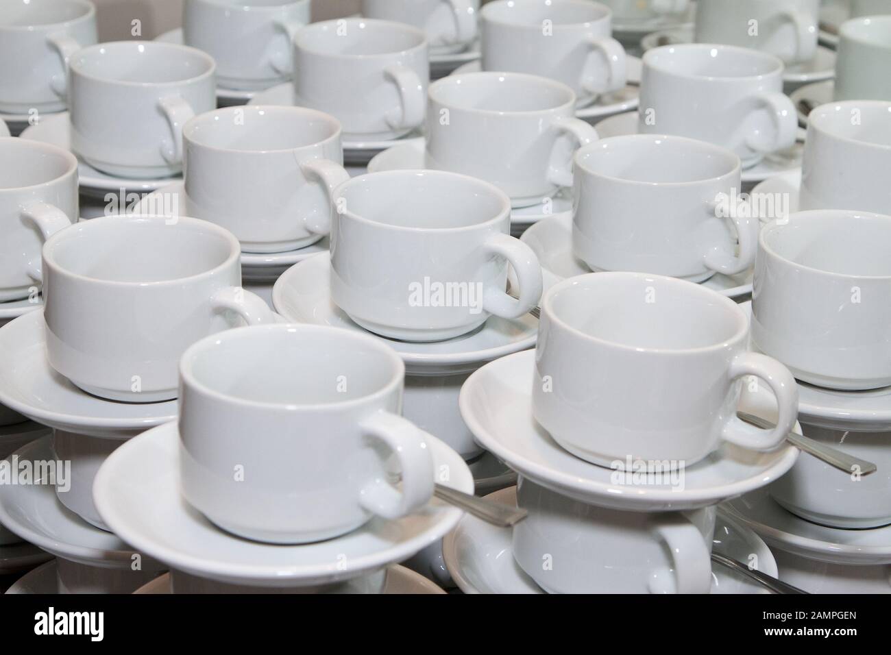 Rows of stacked cups and saucers ready for service. Stock Photo