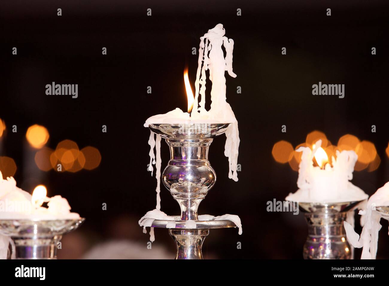 Burning candles in elegant silver candle candleholders. Stock Photo