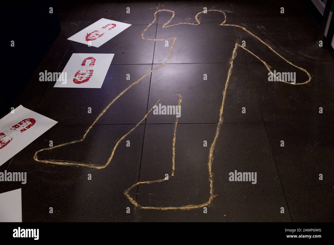 Mock crime scene with bloodied footprints and chalk body outline. Stock Photo
