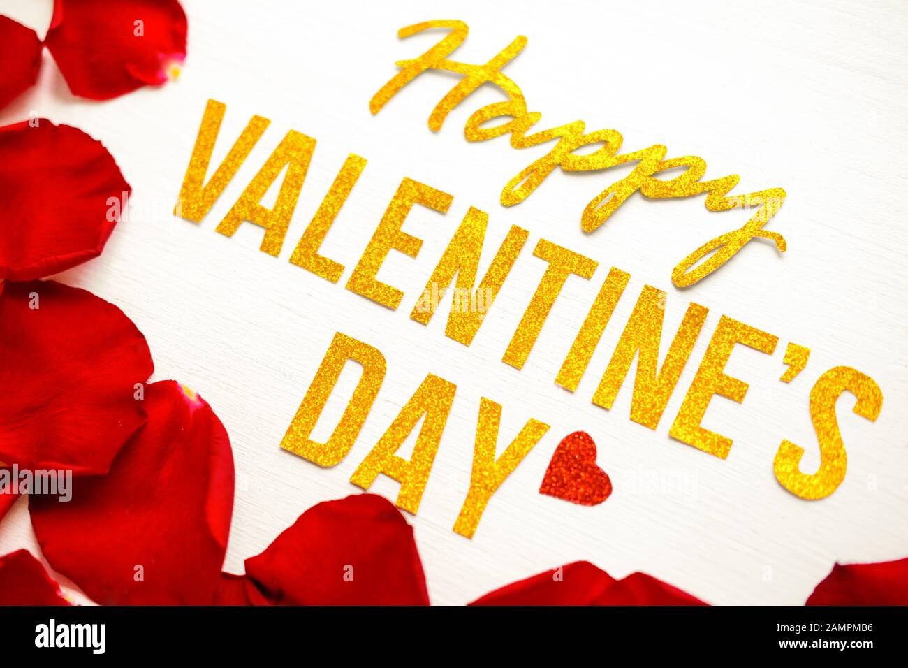 Happy Valentines Day gold text greeting card with red rose petals on ...