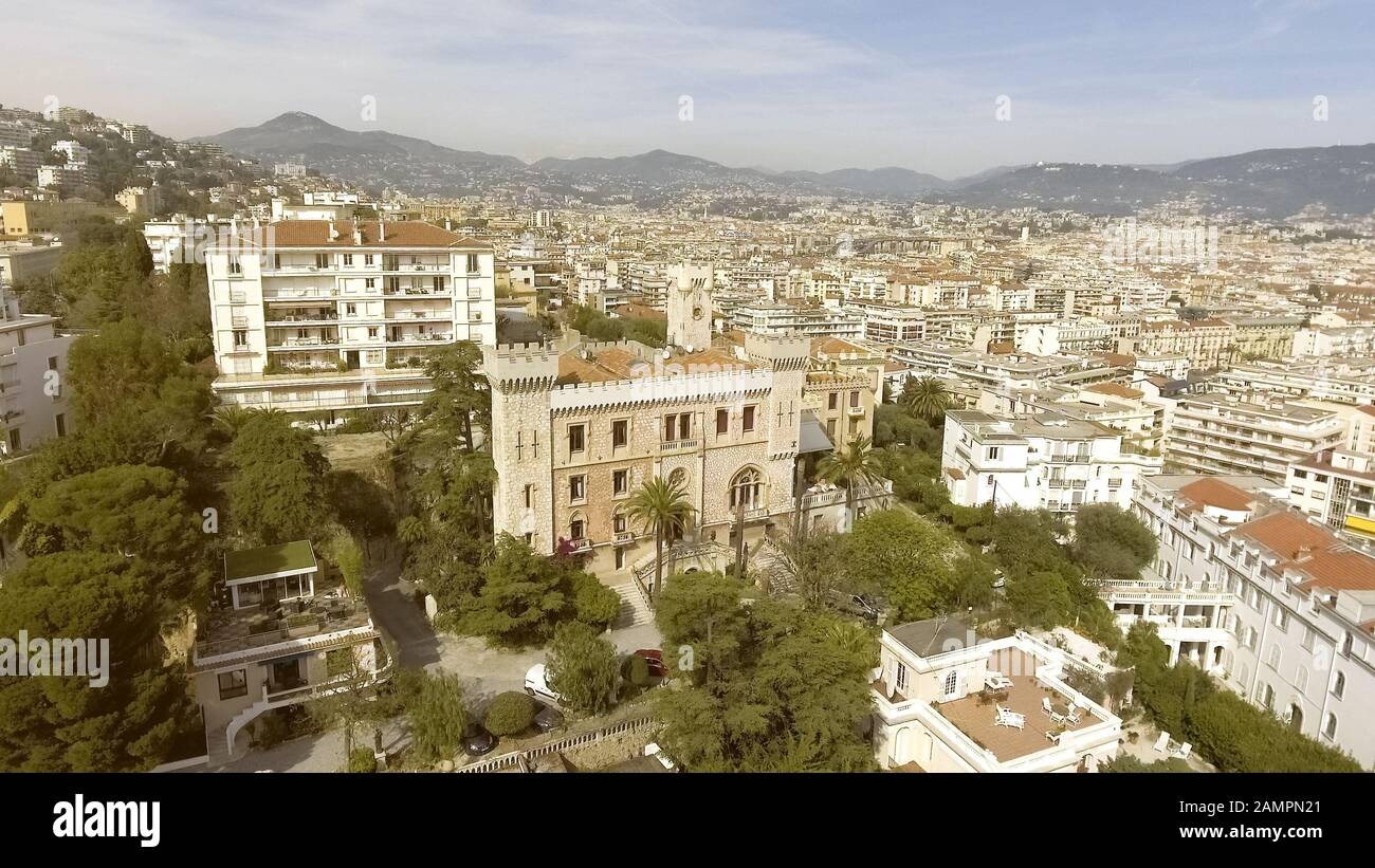 Luxurious castle-like mansion standing in city among apartment houses, aerial Stock Photo