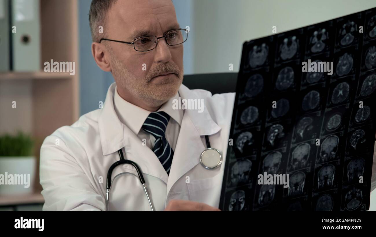 Concerned doctor finds pathologies on mri image of cerebral cortex, diagnostics Stock Photo