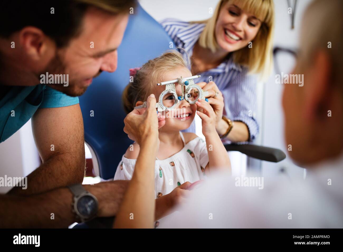 Ophthalmologist is checking the eye vision of little cute girl in modern clinic. Stock Photo