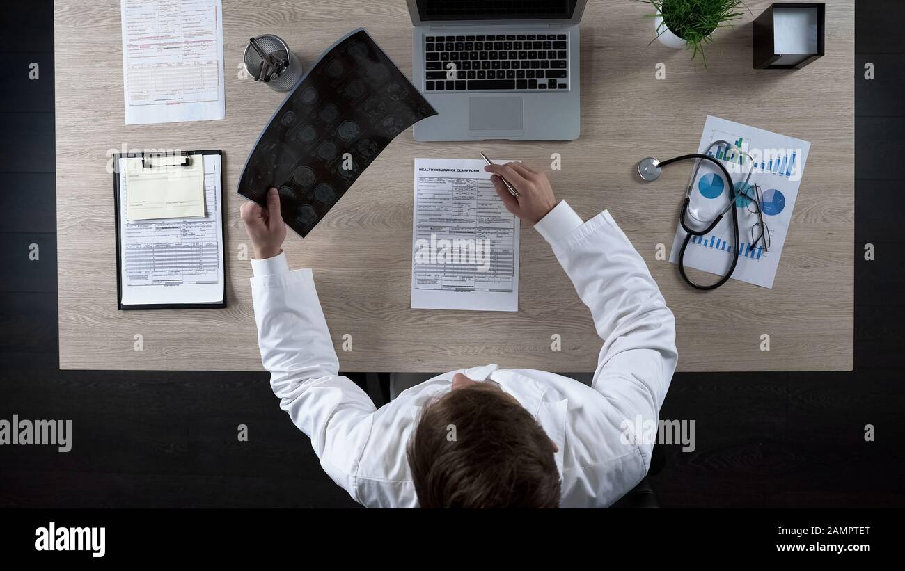 Surgeon analyzing human brain MRI scan, medical tests for diagnostics