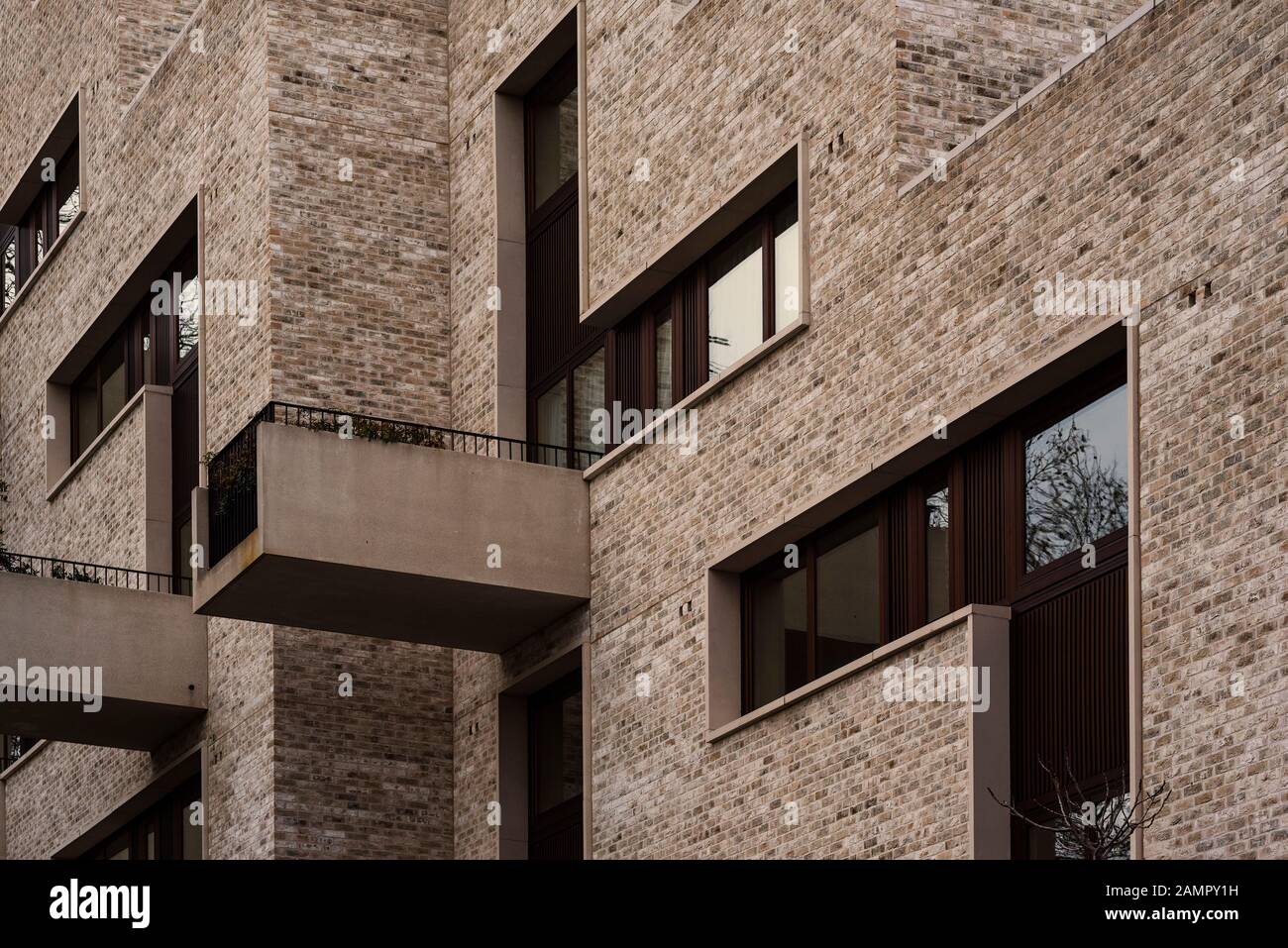 Modern flats / apartment block with irregular geometrical windows and long projecting balconies. Stock Photo