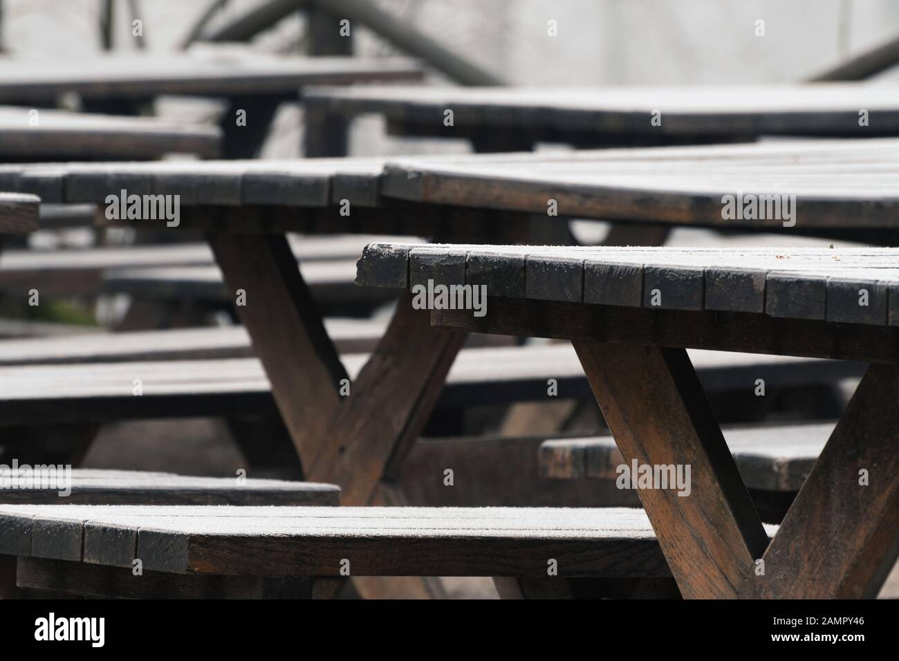 Wooden tables and benches covered with thin layer of hoarfrost. Weather and season concepts Stock Photo