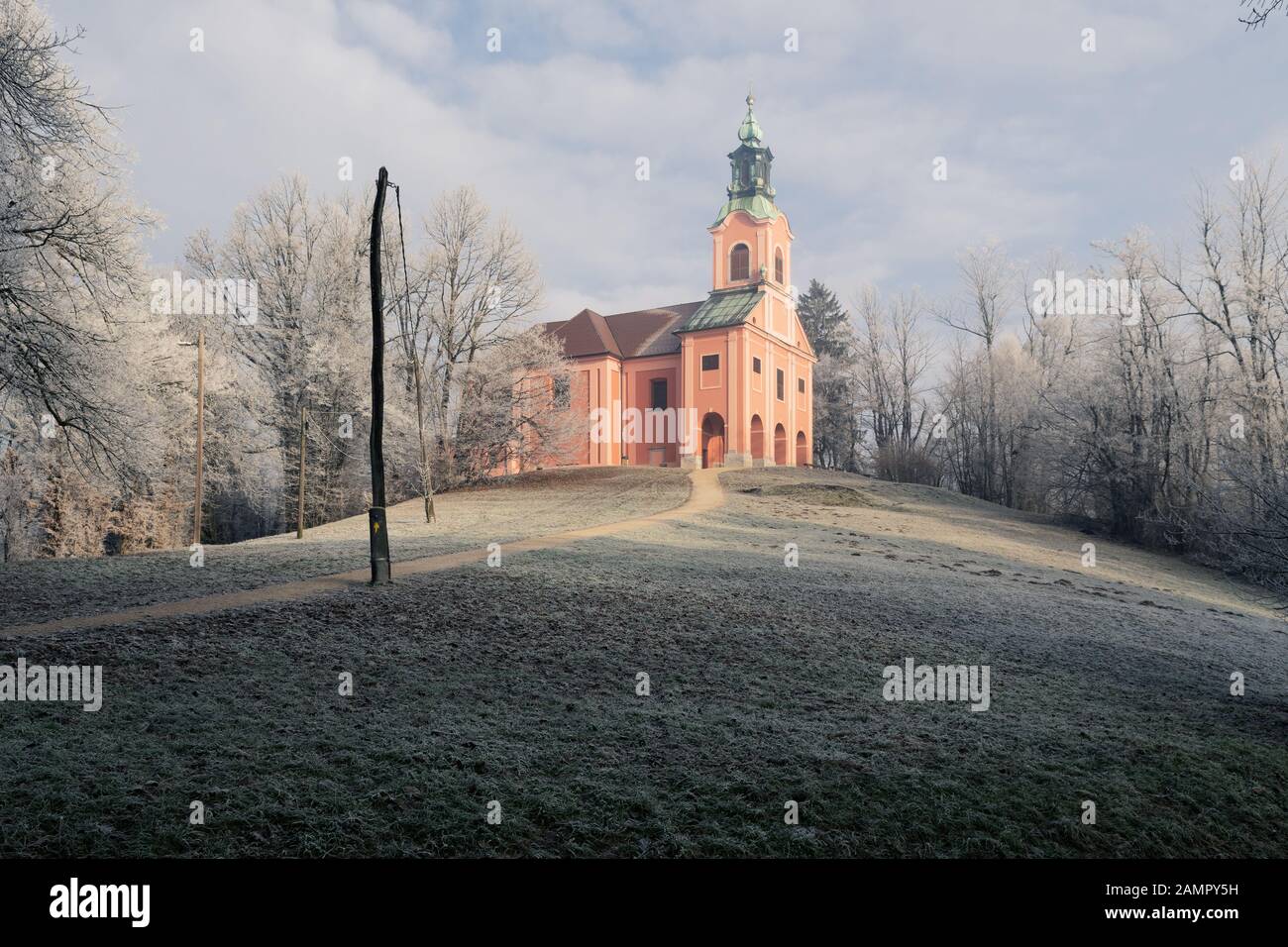 Old catholic church on top of the Roznik hill in Ljubljana on sunny winter morning in Slovenia. Travel, tourism, beauty of nature and weather concepts. Stock Photo