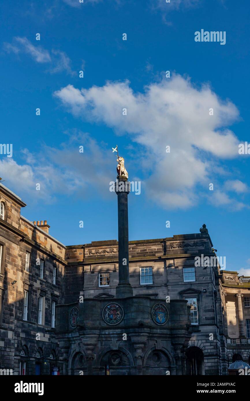 The Unicorn statue called Mercat Cross with golden light shining on it.  The Edinburgh City Chambers are in the background. Stock Photo