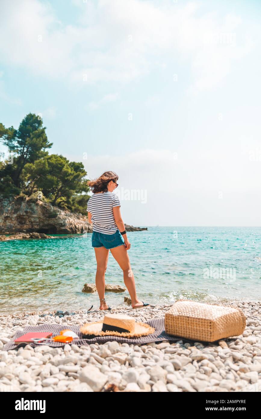 Young Pretty Woman In Summer Outfit Walking By Sea Shore Blanket With Beach Stuff On Blanket Stock Photo Alamy
