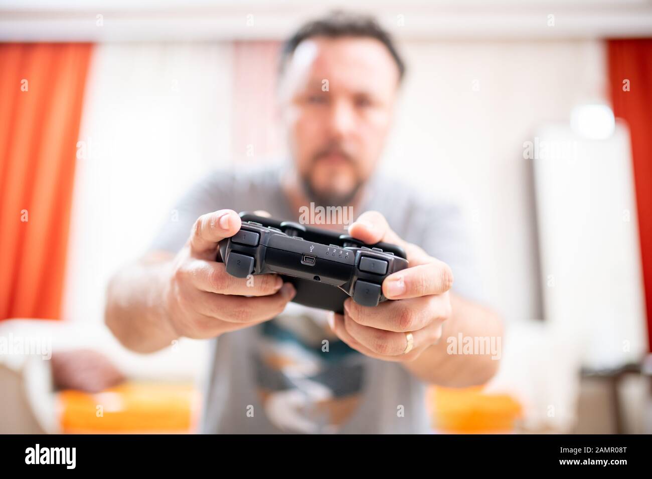 Premium Photo  Close up of gamer holding controller to play video games in  front of computer. player using joystick and playing online games on  monitor, sitting at desk. man gaming with