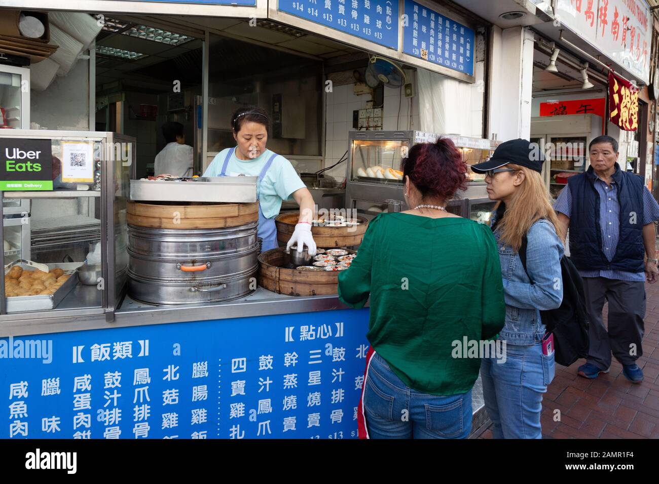 Asia street food; people buying food at a street stall, Kowloon, Hong Kong Asia - example of Asian lifestyle Stock Photo