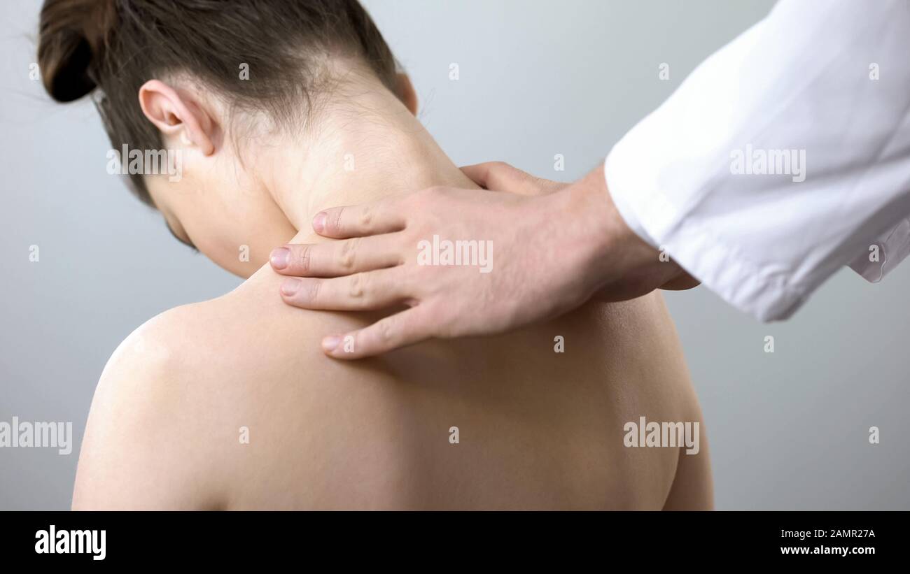 Neurologist touching female shoulders, doctor examining spine, healthcare Stock Photo