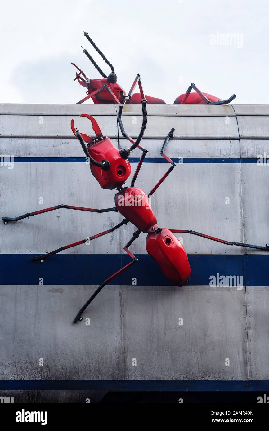 Red ant sculptures crawling over a train carriage at a restaurant in London Bridge, London,UK. Stock Photo