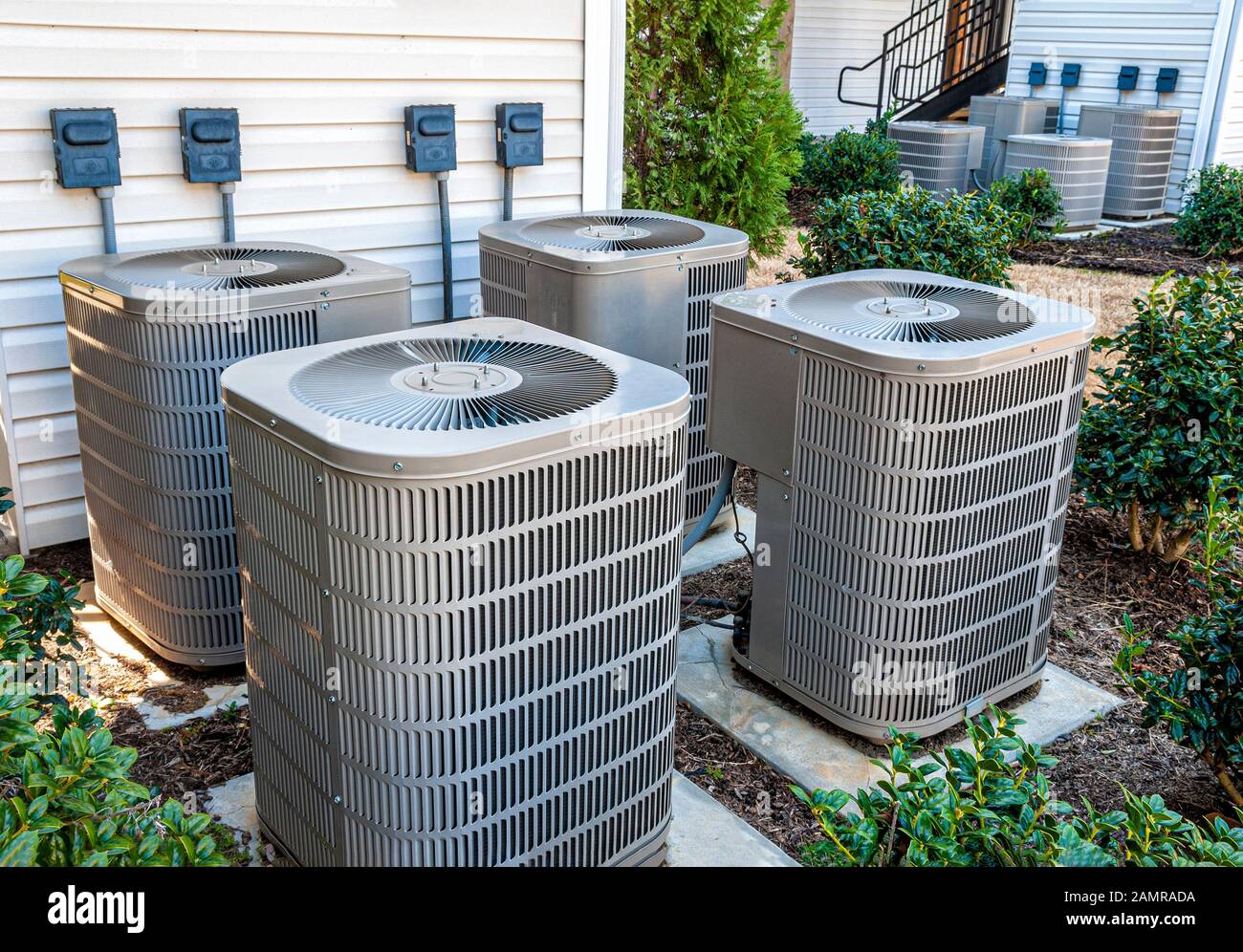 Horizontal shot of four apartment air conditioners outside. Stock Photo