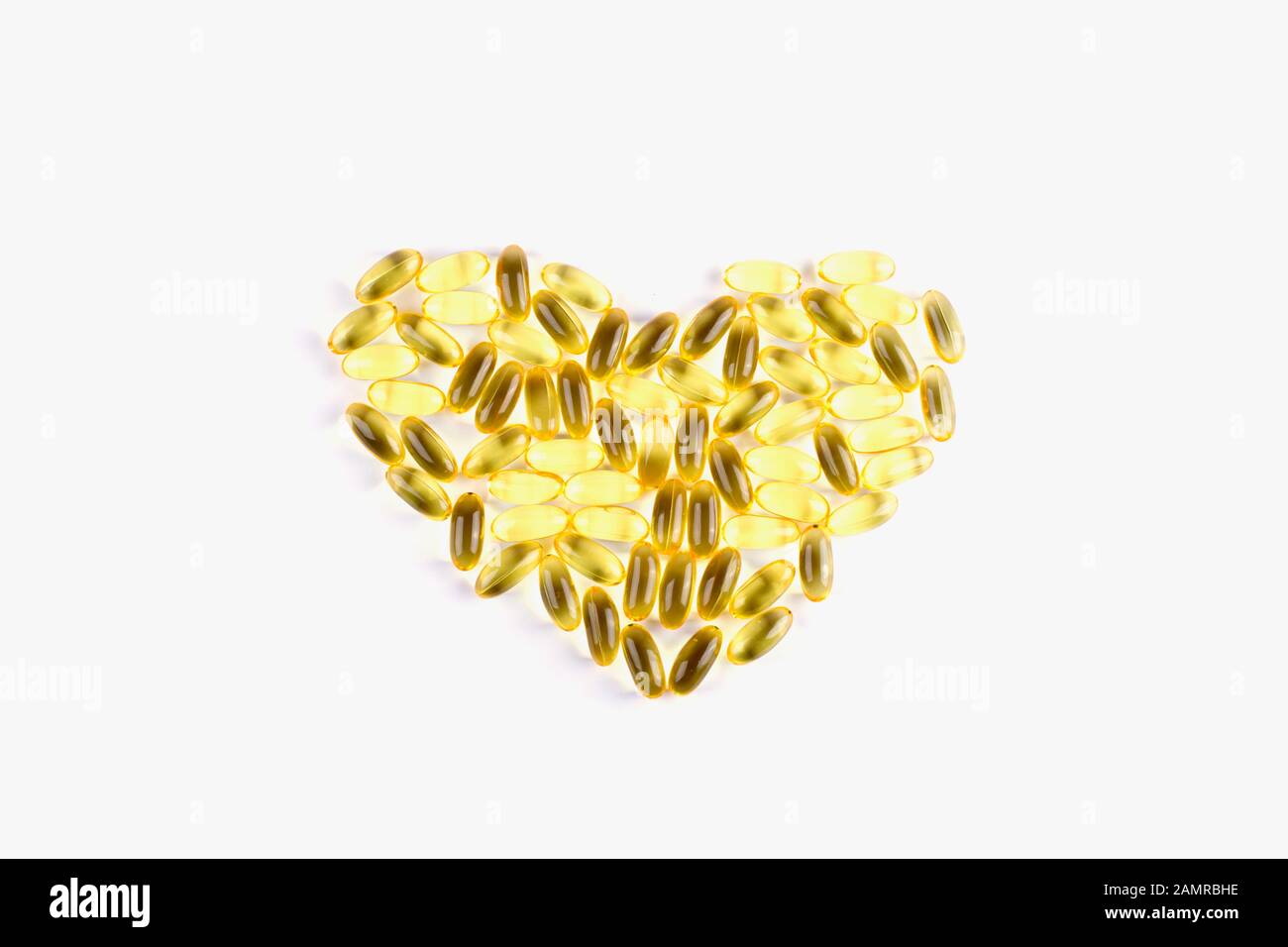Heart shape of fish oil supplement capsules isolated on white