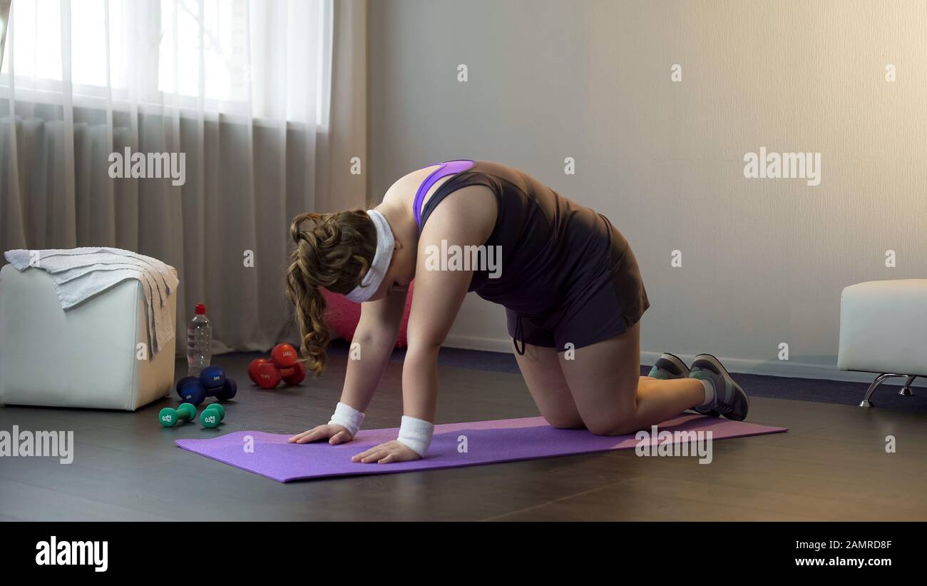 Plump girl doing physical strengthen back exercises, losing extra weight Stock Photo