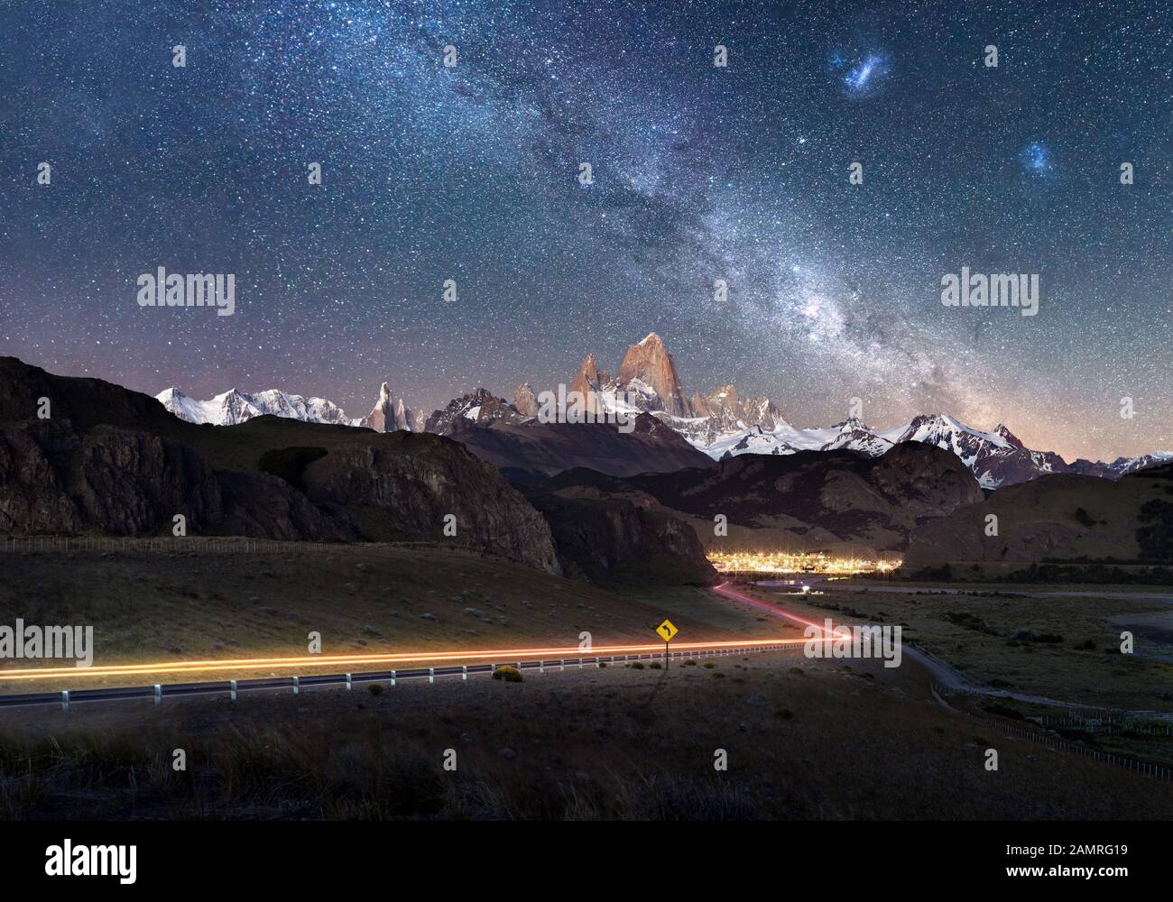 Beautiful light trails towards remote town El Chalten - Fitz Roy Mountain visible under Milky Way Stock Photo