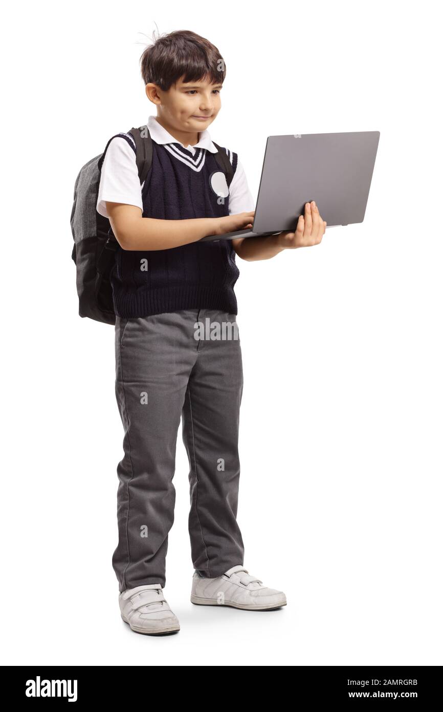 Full length portrait of a schoolboy standing and using a laptop ...