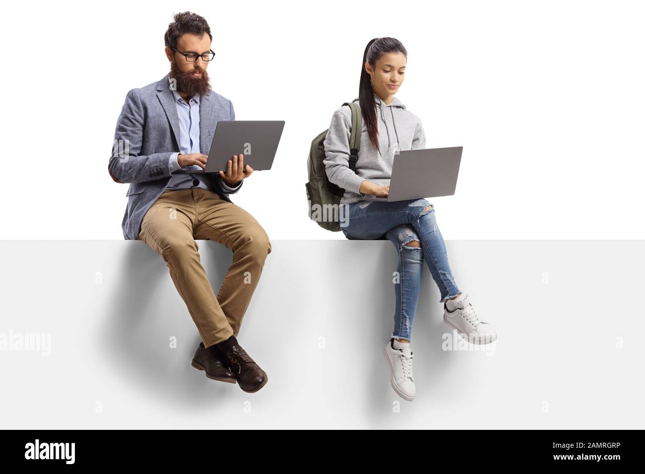 Male teacher and a female student with laptop computers sitting on a panel isolated on white background Stock Photo