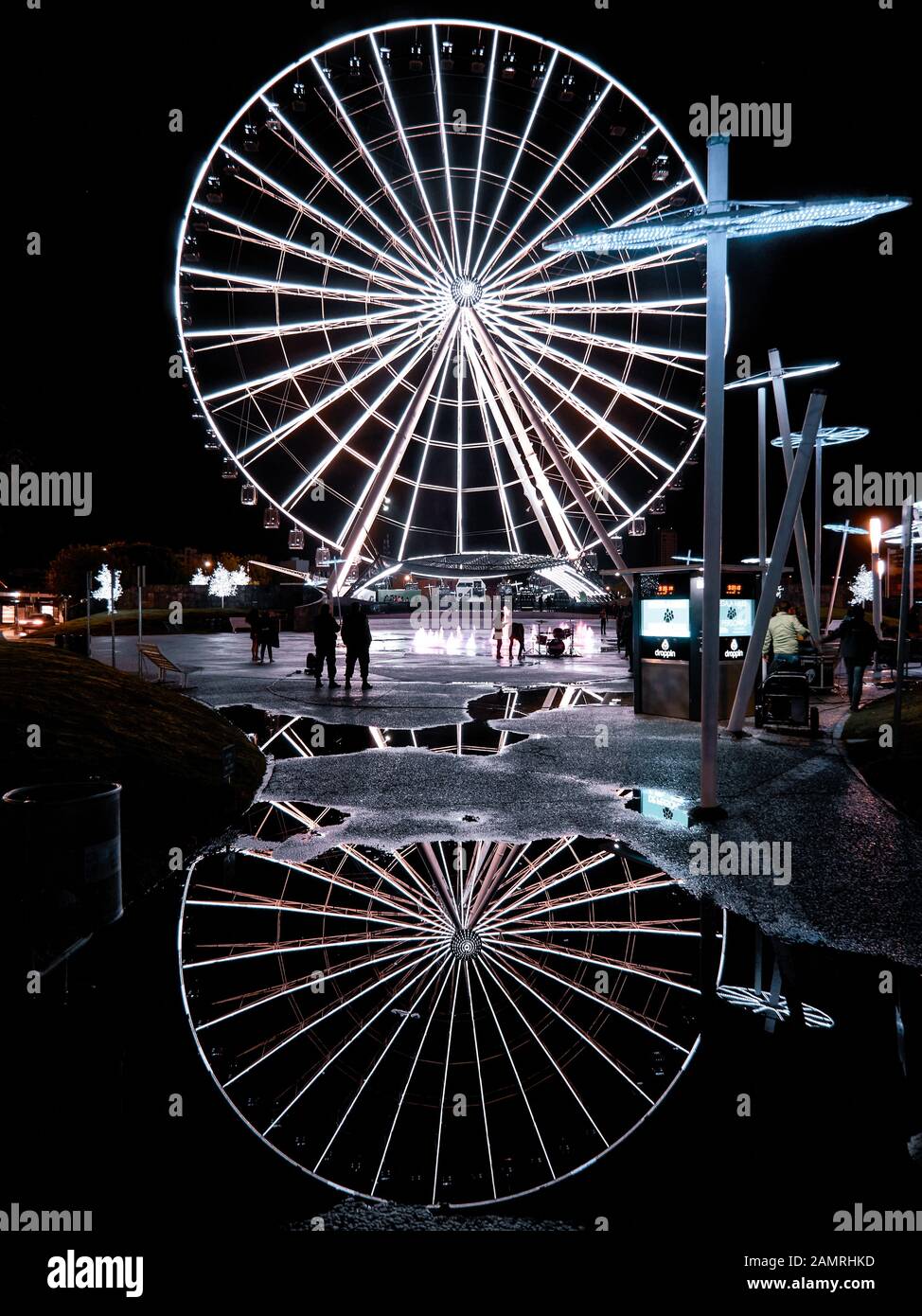 Huge observation wheel Estrella de Puebla with reflection on the water after rain at night Stock Photo